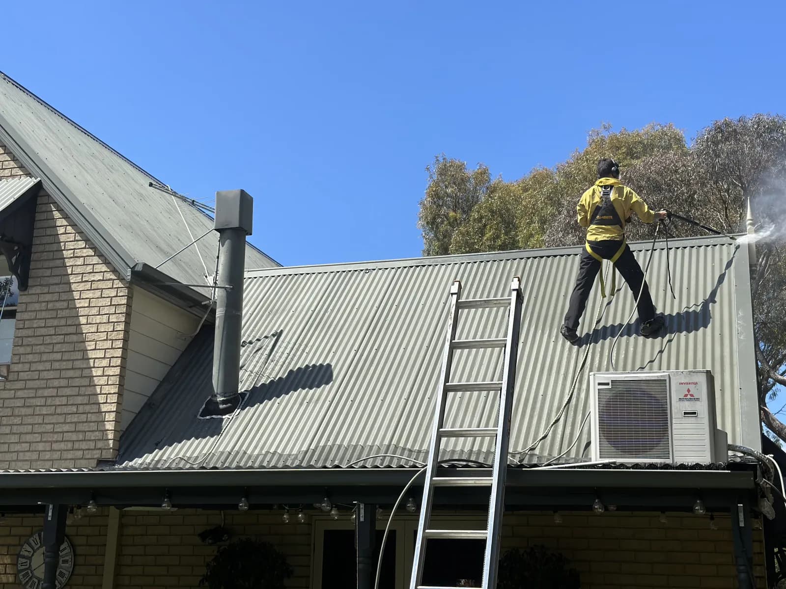 Mike Umarov, owner of Frankston Peninsula Roofing, performing professional roof cleaning